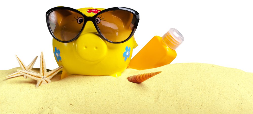 Summer piggy bank with sunglasses on the beach.
Family Vacation Checklist