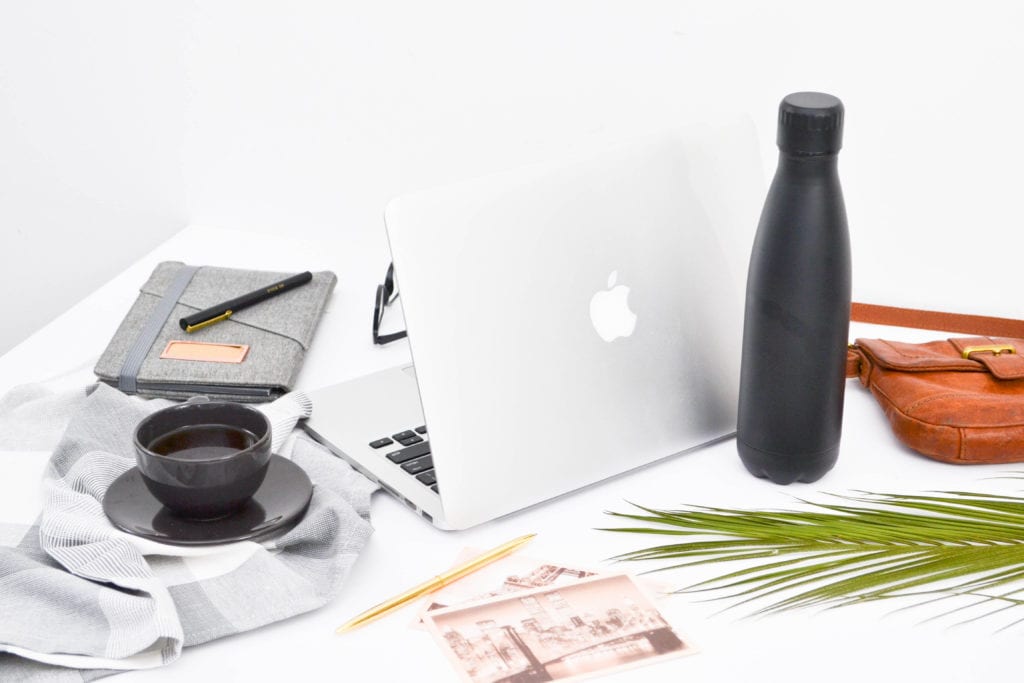 Travel Blogging Course.
Laptop, water bottle, postcards, and coffee.