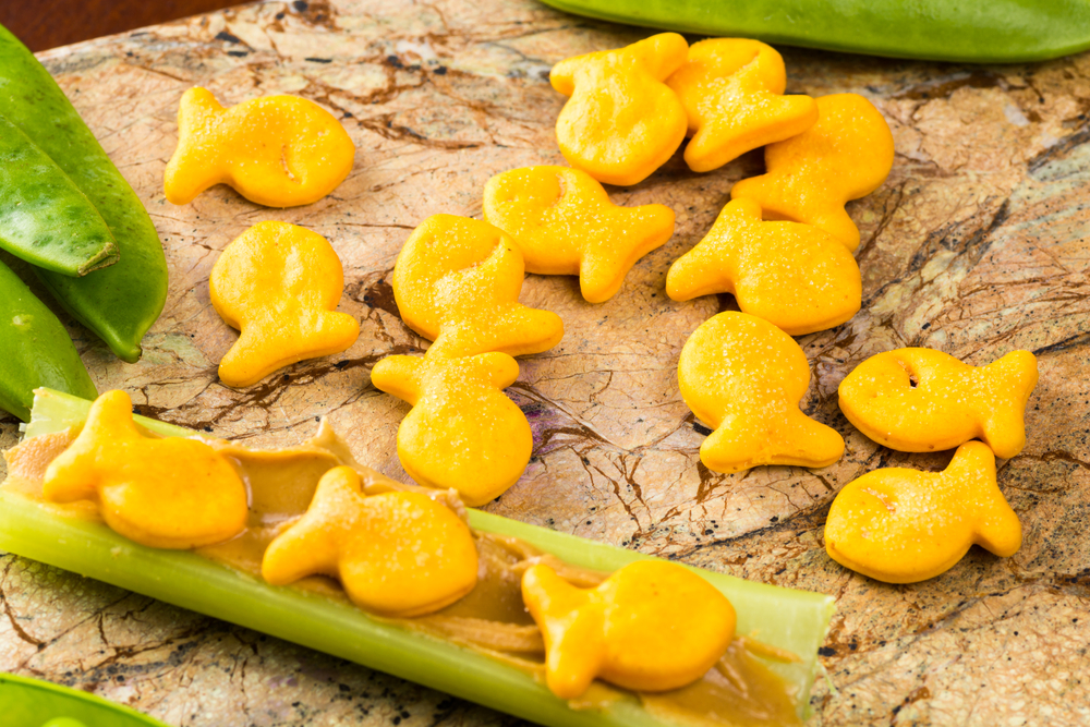 Road Trip Snacks for Kids.
Close up of celery sticks with peanut butter and goldfish crackers - children snack.