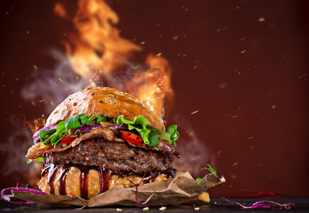 How to stay healthy while on vacation.
Delicious hamburger with fire flames on wooden background