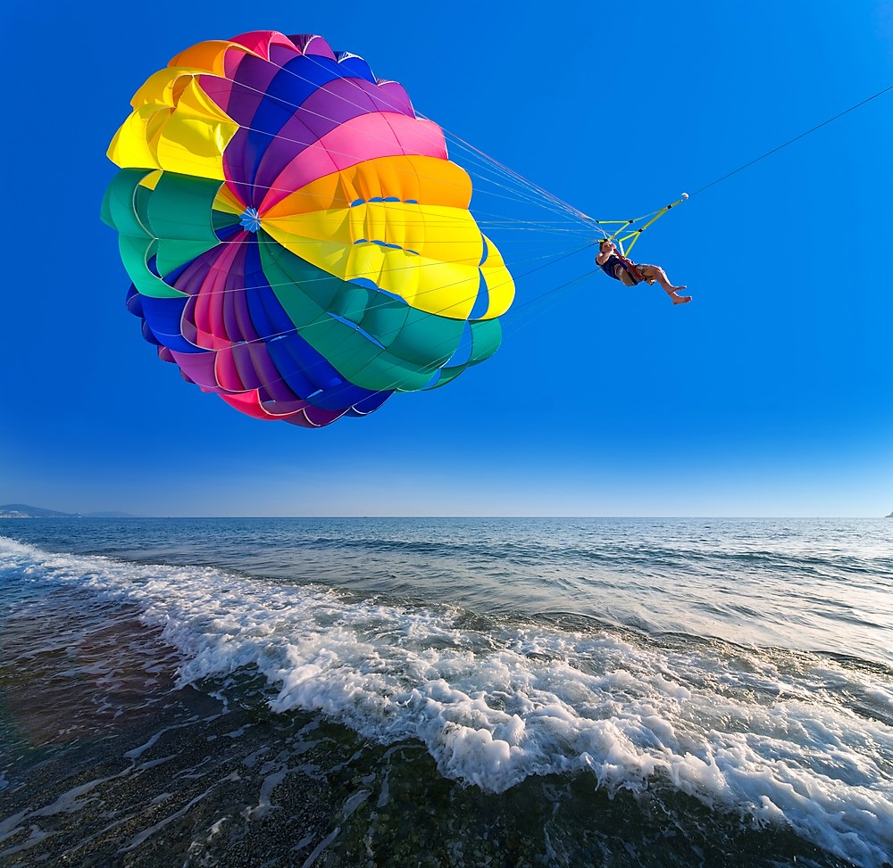 Weekend getaways in Florida.
Man is parasailing in the blue sky