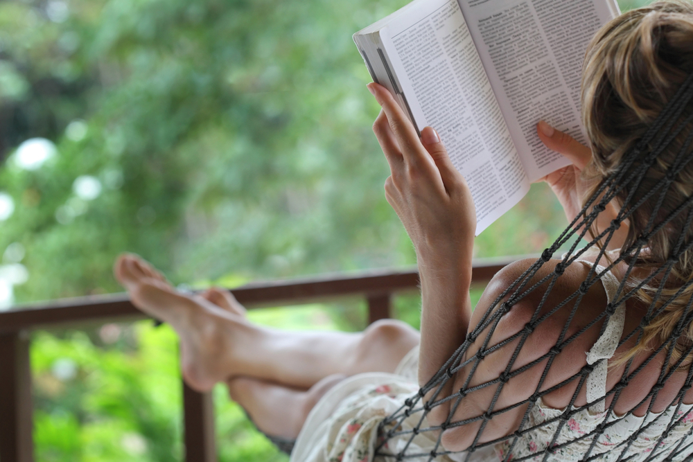 Summer Bucket List Ideas for Teens.
Woman lying in a hammock in a garden and enjoying a book reading