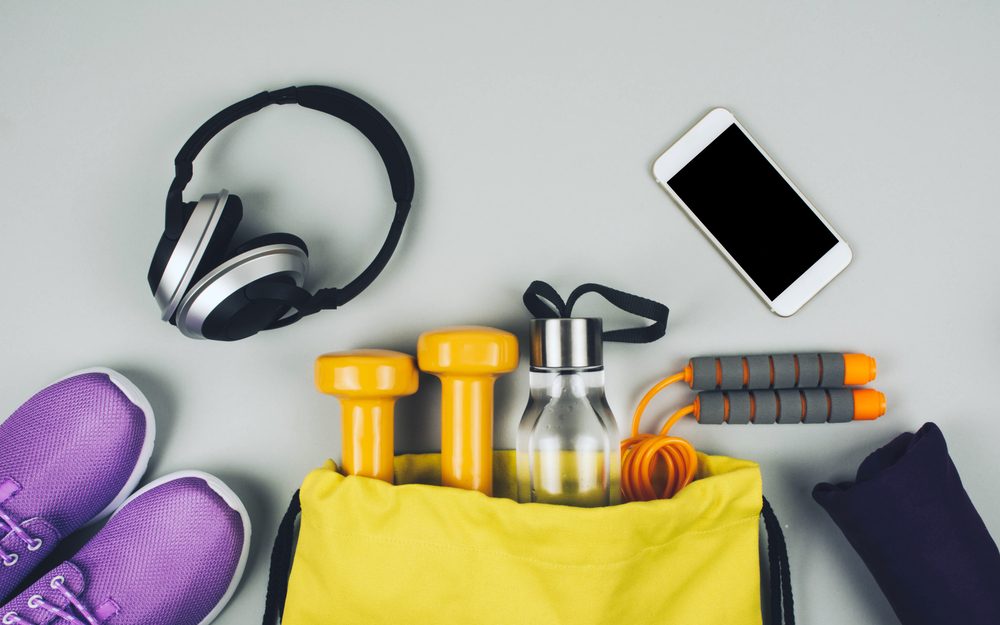 Stress-Free Travel Tips.
Creative flat lay of sport and fitness equipment on gray background with copy space.