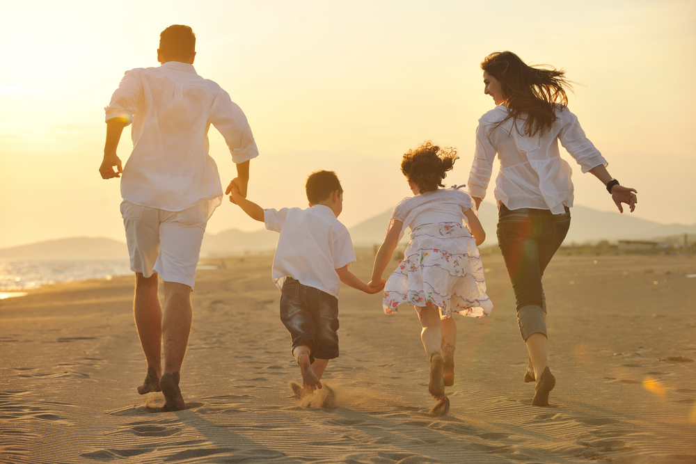 Traveling with Family Quotes.Happy young family have fun on beach run and j...