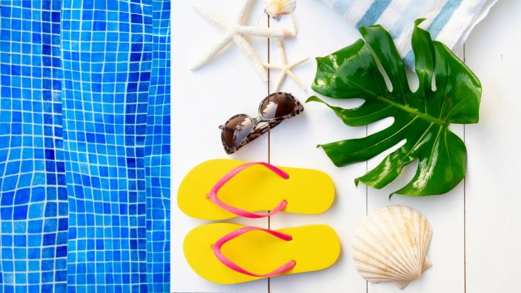 Summer Blogging Slump Flat Lay with Flip Flops, sunglasses, poolside, and a seashell.
