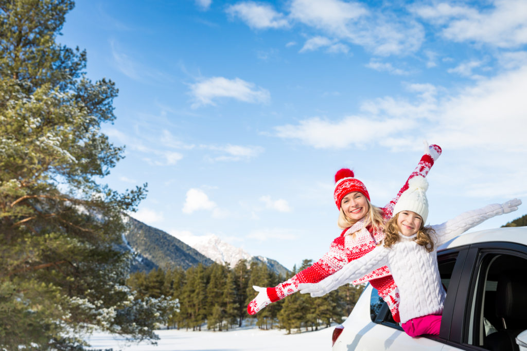 Road Trip Gifts.
Happy family travel by car. People having fun in the mountains. Mother and child on winter vacation. Healthy active lifestyle concept