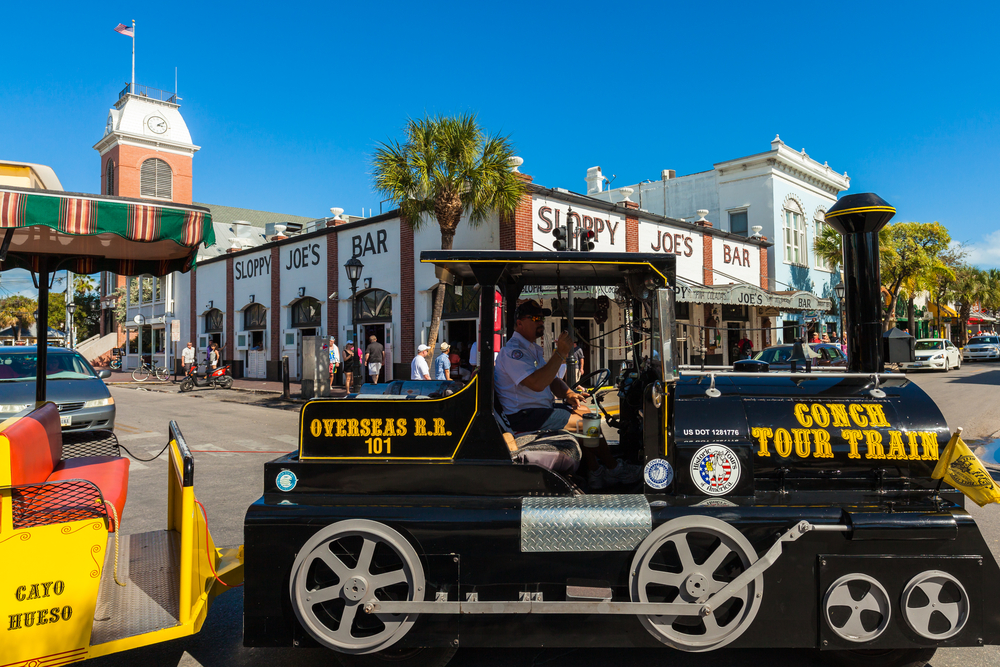 Key West, Florida USA - March 3, 2015: The historic Sloppy Joe's Bar on Duval Street in downtown Key West with the Conch Train.