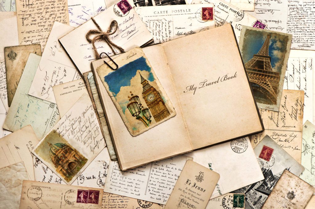 Sustainable Souvenirs.  Old postcards, letters, mails and open journal with sample text My Travel Book. vintage style travel background